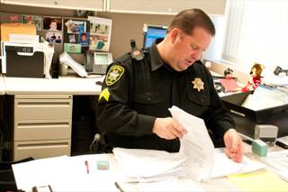 Sgt. Patrick Geary of the Las Vegas Township Constable's Office gets paperwork prepared before heading out in to the city to perform his duties, Wednesday, Dec. 28, 2011.